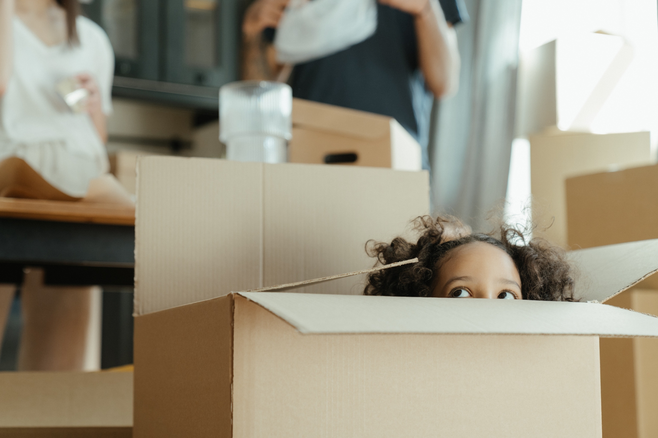 Image of brown cardboard boxed with a child popping out of them